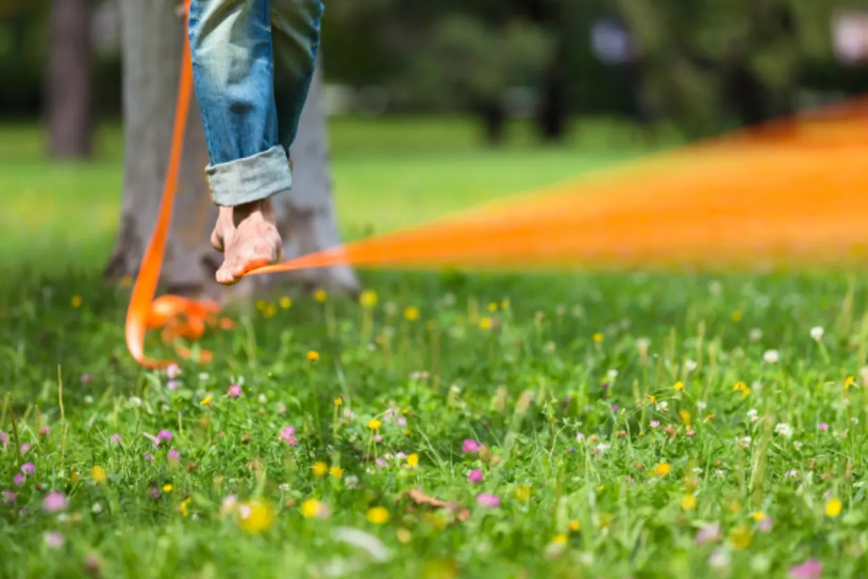 man on slack line in city park mind-body wellness concept